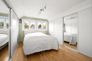 1 dormitorio con 2 camas y espejo en Enebolig sentralt i Arendal., en Arendal