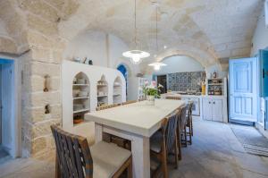 una cucina con tavolo e sedie bianchi di Casa dei 5 Camini with terrace a Ortelle
