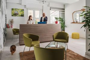 twee vrouwen aan een balie in een kamer met stoelen bij Nido Suite & Apartments in Cesenatico