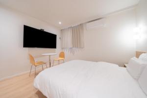 清州市Aank Hotel Cheongju Uam 2nd的一间白色卧室,配有床、桌子和电视 更多37张照片