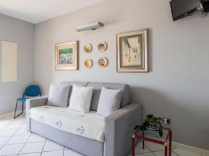 sala de estar con sofá y cuadros en la pared en Casa nel Blu en Portoscuso