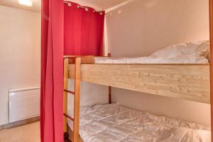 sypialnia z 2 łóżkami piętrowymi z czerwoną zasłoną w obiekcie Vue Montagne 4 étoiles w mieście Saint-Lary-Soulan