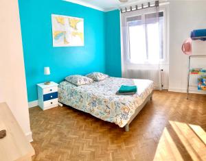 a bedroom with a bed and a blue wall at Appartement rénové 80 m2 in Foix
