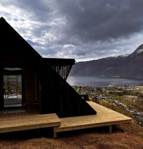 a wooden cabin with a view of a lake and mountains at Cozy house in Eidfjord in Eidfjord