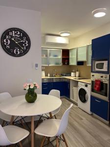 a kitchen with a table and chairs and a clock on the wall at Last Minute Herzliya in Herzelia 