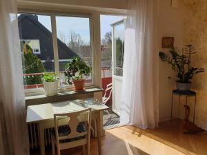 Cette chambre dispose d'une table et d'une fenêtre avec des plantes en pot. dans l'établissement Egen ovanvåning i charmig villa nära havet, à Ystad