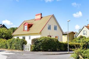 a white house with a red roof on a street at Egen ovanvåning i charmig villa nära havet in Ystad