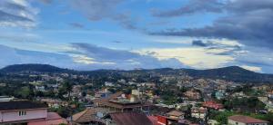 a view of a city with houses and mountains at Coorg North Breeze Homestay in Madikeri