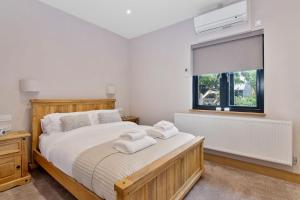 a bedroom with a large bed with towels on it at The Roost Group - 29 Guests - Two Luxury Barns in Gravesend