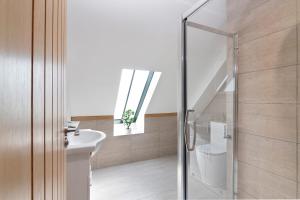 ein Bad mit einem Waschbecken, einem WC und einem Fenster in der Unterkunft The Roost Group - 29 Guests - Two Luxury Barns in Gravesend