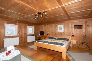Raggal的住宿－Haus Holzwurm，卧室配有一张床铺,位于带木墙的房间内