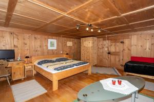 a bedroom with a large bed in a room with wooden walls at Haus Holzwurm in Raggal