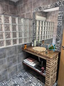 een badkamer met een wastafel en een spiegel bij Open Mind Hostel in Alcalá la Real