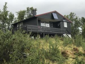 una casa negra sentada en la cima de una colina en Cabin in the Mountain, Outstanding View & Solar Energy, en Vollen
