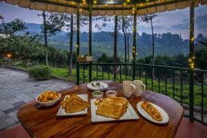 a wooden table with plates of food on it at ama stays & trails - Dulwich Park View in Panchgani