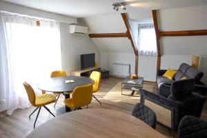 a living room with a table and yellow chairs at L'Appart de La Grande Boutique du Vin Beaune in Beaune