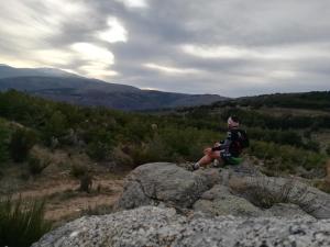 un hombre sentado en una roca en una montaña en Casa Ensueño-Los Sitios de Aravalle, en Gilgarcía