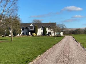 a large white house on a green field with a dirt road at North Cottage Marlfields Hall, Stunning Location in Adlington