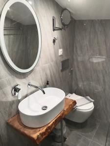 a bathroom with a sink and a toilet and a mirror at Hotel Almira in Agia Triada