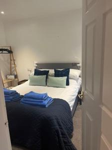 a bedroom with a bed with blue sheets and pillows at North Cottage Marlfields Hall, Stunning Location in Adlington