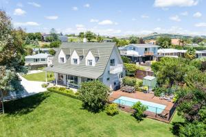 an aerial view of a house with a swimming pool at Live Large in the Village in Havelock North