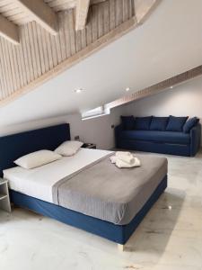a bedroom with a bed and a blue couch at Hotel Almira in Agia Triada