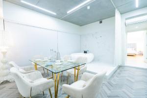 a dining room with a glass table and white chairs at Randor Hotel Hiroshima Prestige in Hiroshima