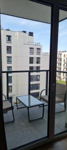 a balcony with a table and two chairs and a building at Airport Apartment in Warsaw