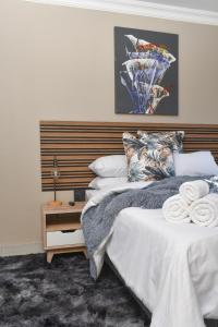 1 dormitorio con 1 cama grande y cabecero de madera en Falcons Rest en Pretoria