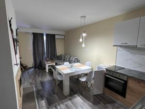 cocina y sala de estar con mesa blanca y sillas en Аpartment B201 Grand Bansko 1, en Bansko