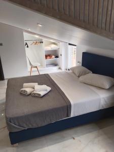 a bedroom with a large bed with towels on it at Hotel Almira in Agia Triada