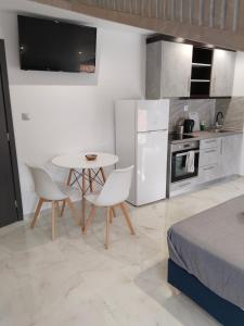 a small kitchen with a table and chairs in a room at Hotel Almira in Agia Triada