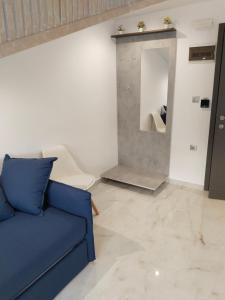 a living room with a blue couch and a mirror at Hotel Almira in Agia Triada