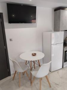 a small kitchen with a white table and chairs at Hotel Almira in Agia Triada