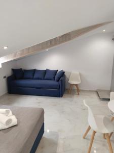 a living room with a blue couch and a table at Hotel Almira in Agia Triada