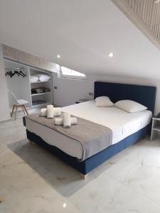 a bedroom with a large bed with white sheets and pillows at Hotel Almira in Agia Triada