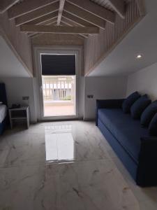 a living room with a blue couch and a window at Hotel Almira in Agia Triada