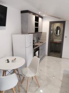 a kitchen with a table and chairs and a white refrigerator at Hotel Almira in Agia Triada