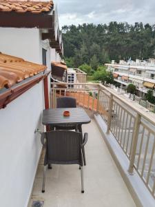 a table and two chairs on a balcony at Hotel Almira in Agia Triada