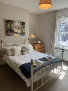 een slaapkamer met een bed met kussens erop bij Sea to City House in Whitley Bay