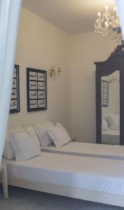 a bedroom with a bed with white pillows and a mirror at Dar Ben Gacem Kahia in Tunis
