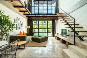 a living room with a staircase and a couch at Berawa Lofts #2 Canggu in Canggu
