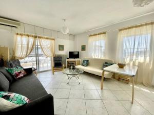 a living room with a couch and a table at Maria´s Sunshine Place in Neos Marmaras