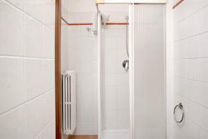 een douche in een badkamer met witte tegels bij Appartamento in Vigna Gallina in Neive