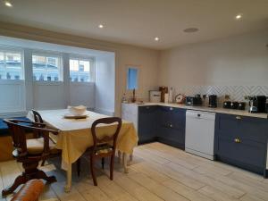 a kitchen with a table and chairs and a kitchen with blue cabinets at Sea Front St Leonards in Hastings