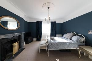 a bedroom with blue walls and a bed and a mirror at Sea Front St Leonards in Hastings