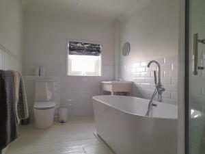 a white bathroom with a tub and a toilet at Sea Front St Leonards in Hastings