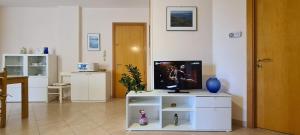 a living room with a tv on a white cabinet at Nonna Eleonora in Otranto