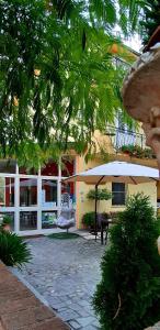 a patio with an umbrella in front of a building at B&B Cuoreverde Pollino in Rotonda
