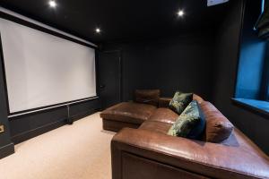 a theater room with a couch and a large screen at Sea Front St Leonards in Hastings